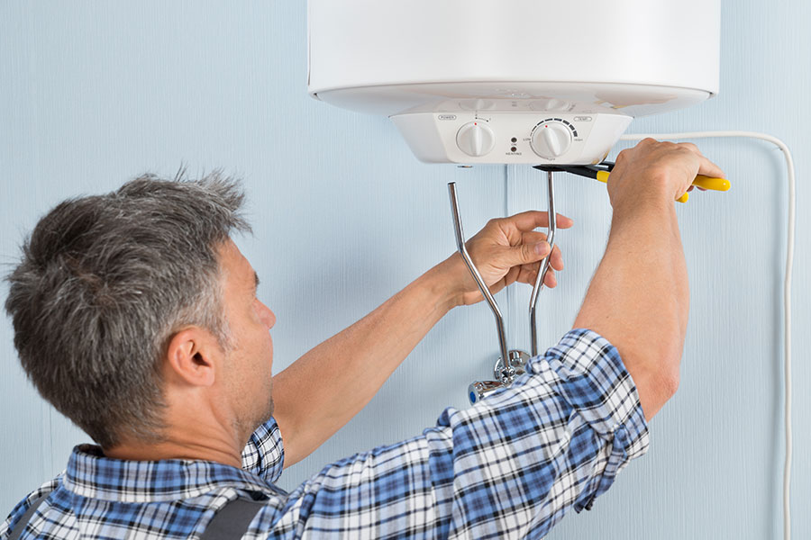 Man repairing a water heater for his small plumbing business in Springfield, IL